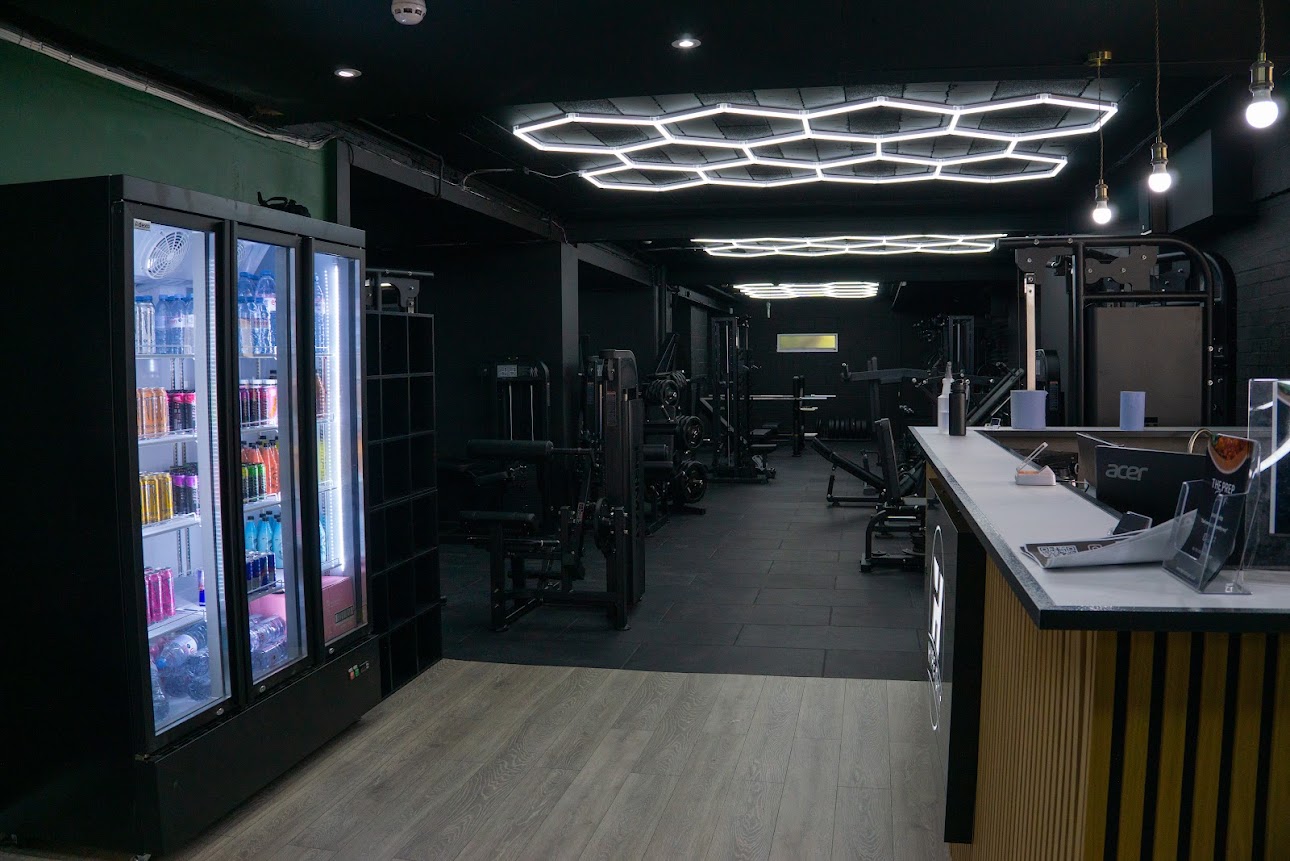 Hype Gym reception area with drinks fridge and view into the gym floor